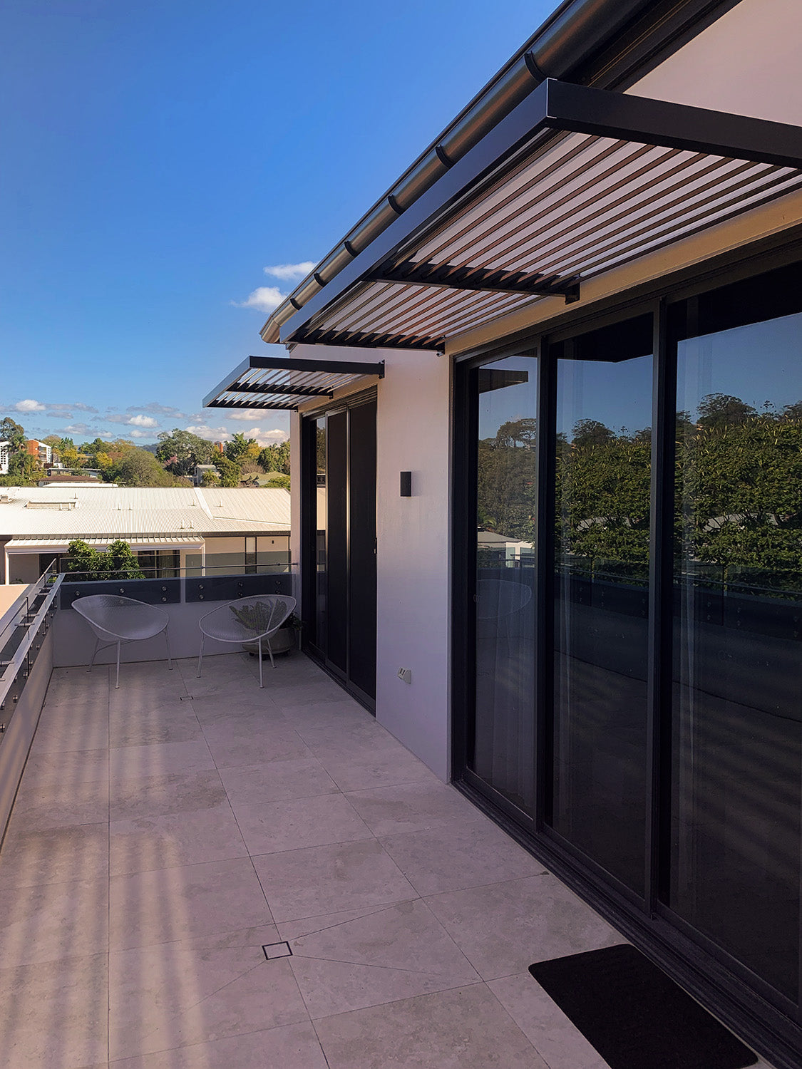Clik'n'Fit Louvre Aluminium Awning 90° Angle in Black Night Sky installed over balcony doors.